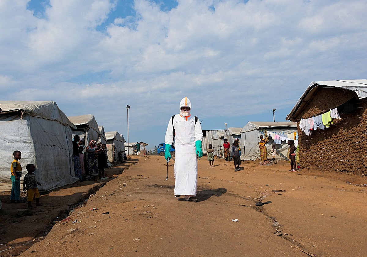 Un sanitario se prepara para una desinfección en un campamento de desplazados de Kigonze, Congo.