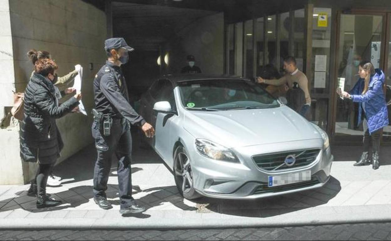 Familiares y amigos muestran carteles de Esther López al coche en el que Óscar salió del juzgado.