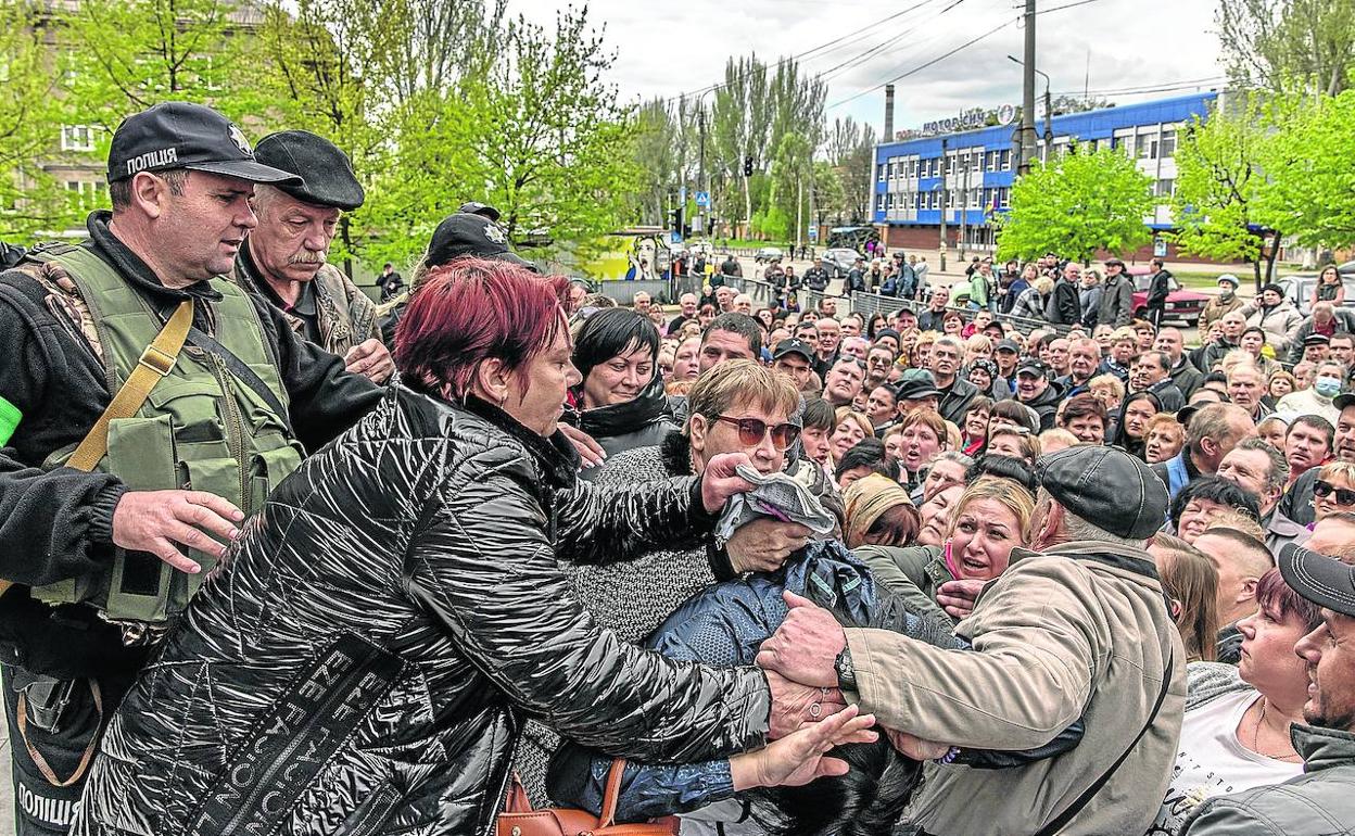 Cientos de familias se agolpan ante un puesto de control de Zaporiyia para recibir ayuda humanitaria.