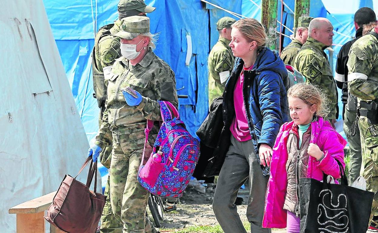 Varios de los refugiados abandonan Mariúpol escoltados por soldados de las milicias prorrusas. 