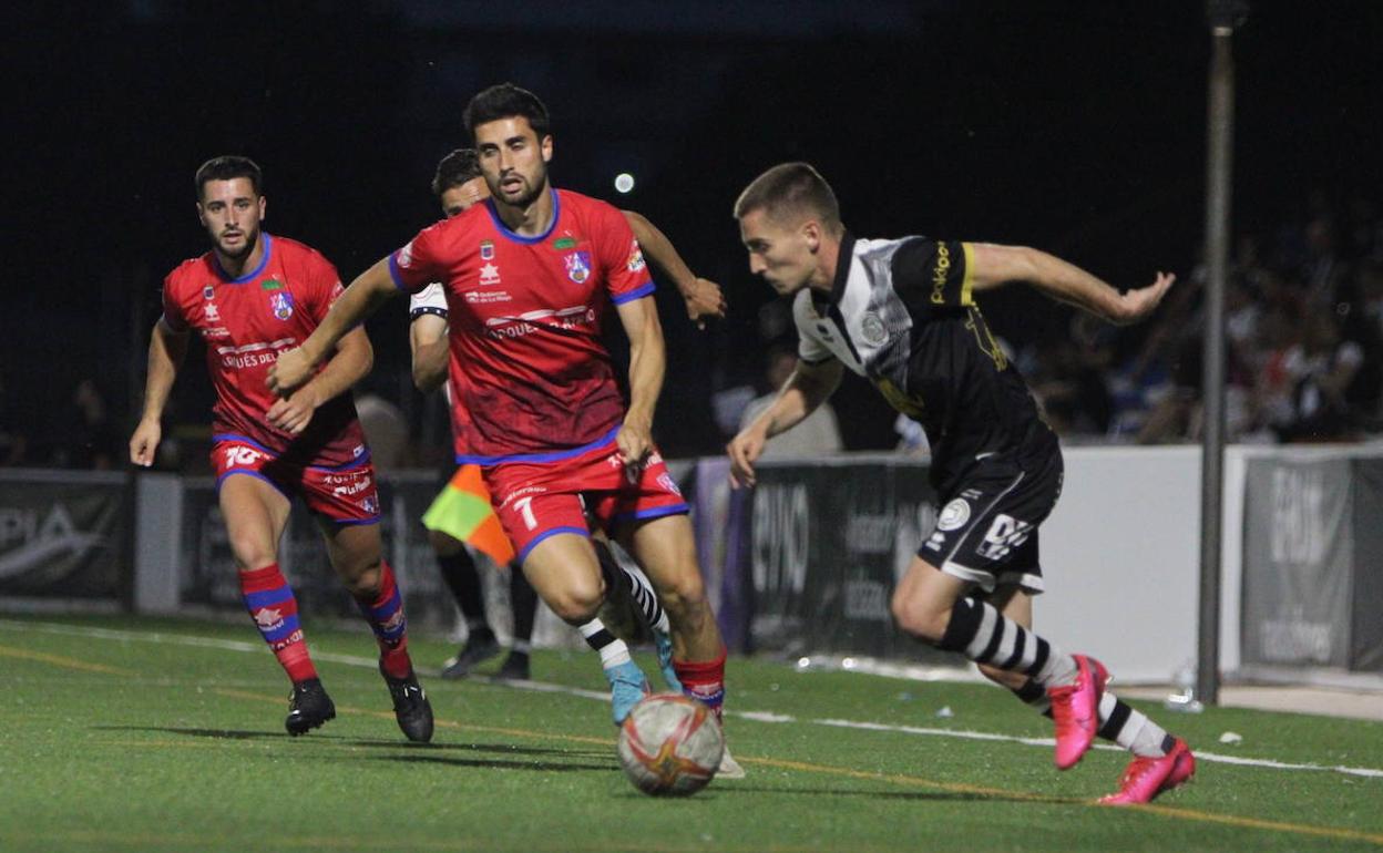 Íñigo Muñoz conduce el balón perseguido por dos rivales del Calahorra.