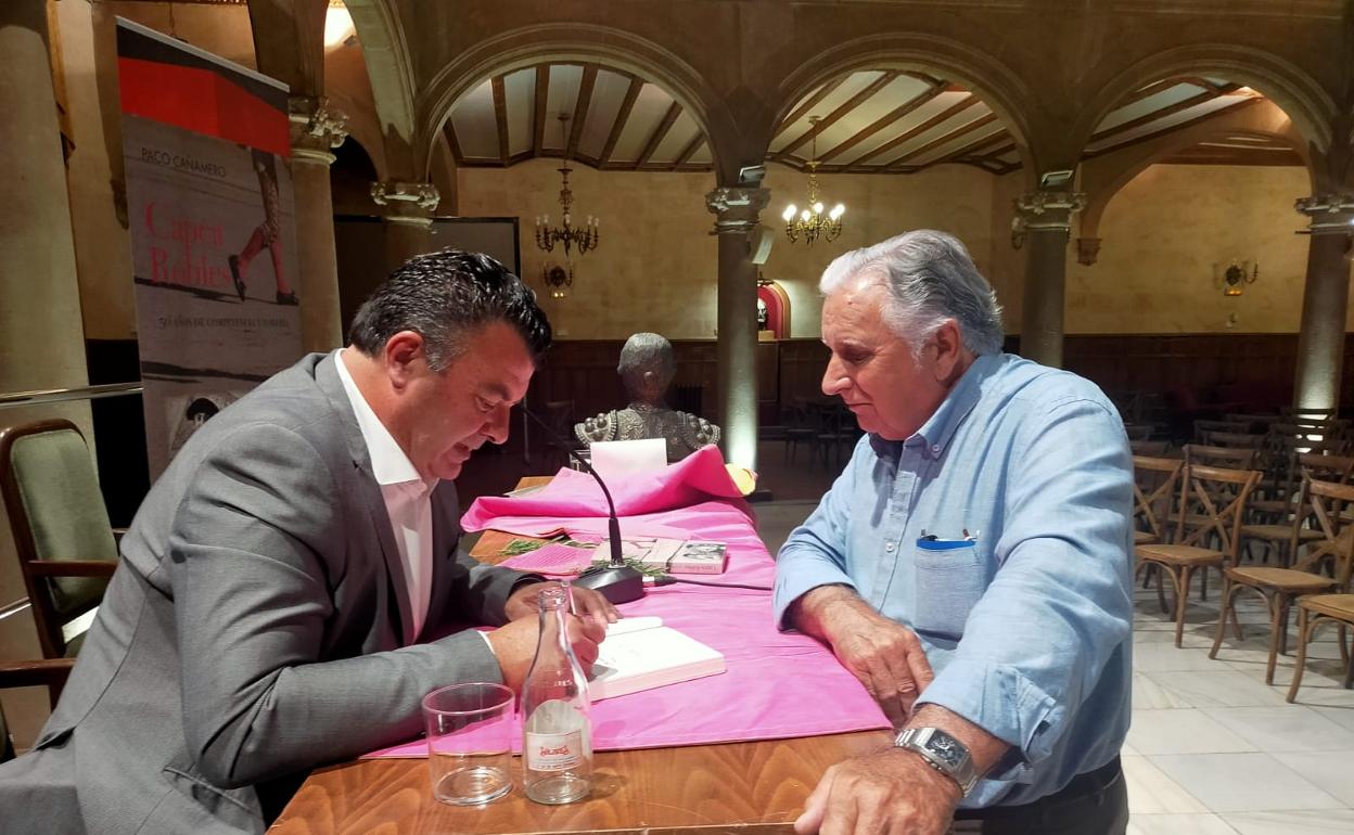 Cañamero firma un libro a un aficionado.