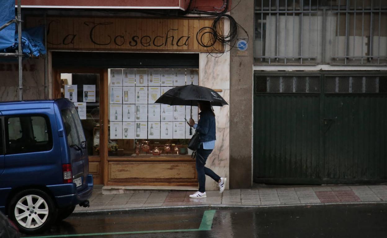 Una persona con paraguas en Salamanca.