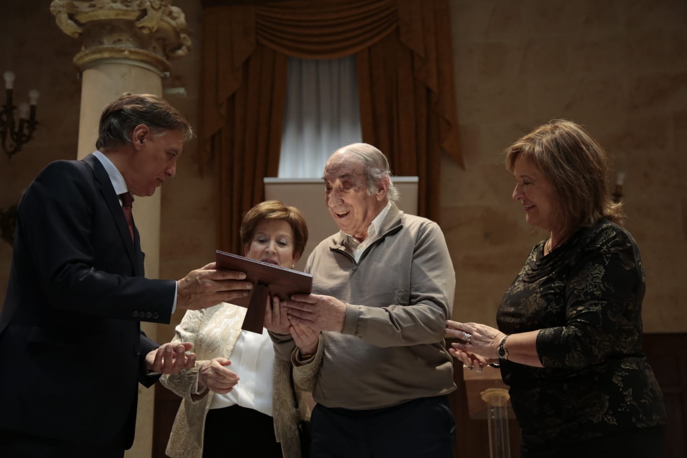 El alcalde entrega un recuerdo a un matrimonio. 