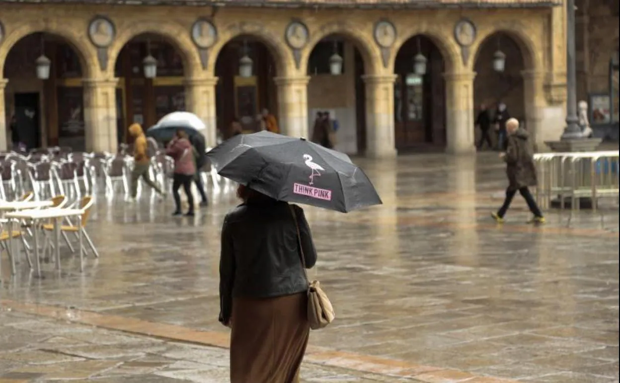 Gente con paraguas en la Plaza Mayor, un día de lluvia de noviembre. 