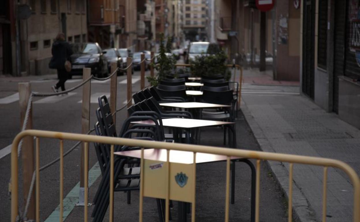 Una terraza ocupando una zona de aparcamiento de la ORA en una calle de la ciudad.