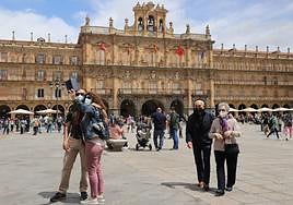 Varios turistas pasean y se fotografían en la Plaza Mayor de Salamanca.