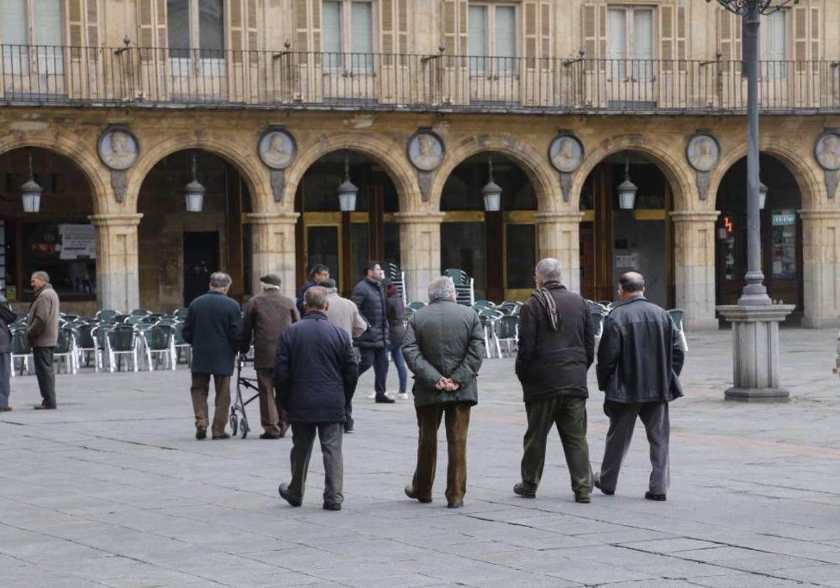 Varios mayores pasean en la Plaza Mayor de Salamanca.