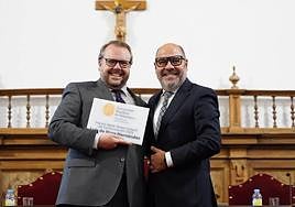 Luis de Vega muestra el diploma tras recibirlo del decano de Comunicación.