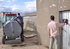 Un hombre llena de agua un tanque.