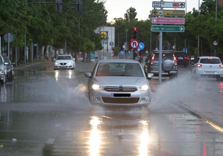 Los coches circulan con la intensa lluvia a primera hora de la mañana.