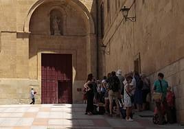 Turistas se refugian del calor a la sombra junto a las catedrales de Salamanca.