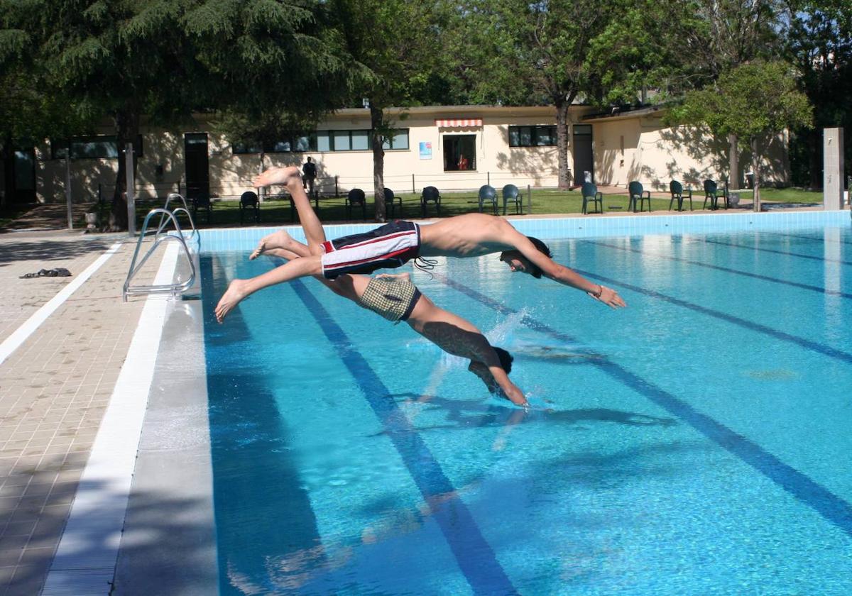 Dos jóvenes lanzándose de cabeza a una piscina.