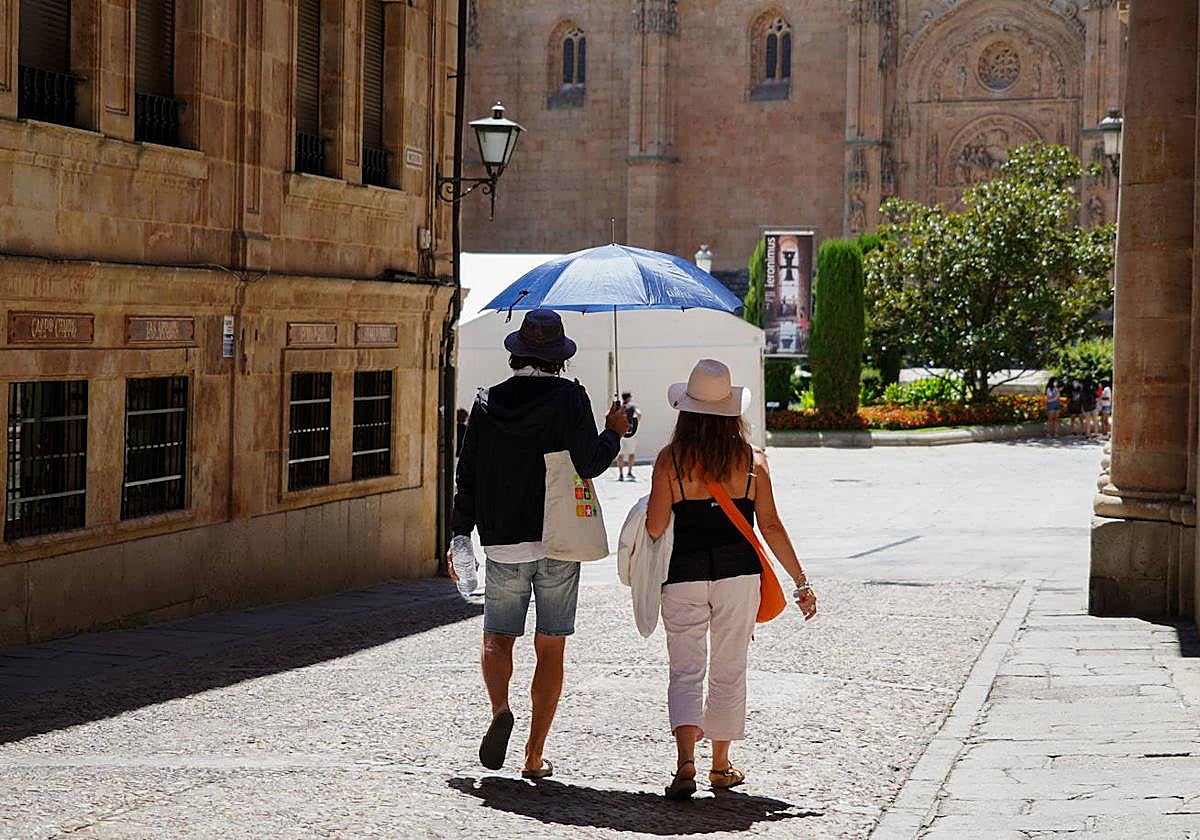 Dos personas caminan hacia las catedrales de Salamanca.