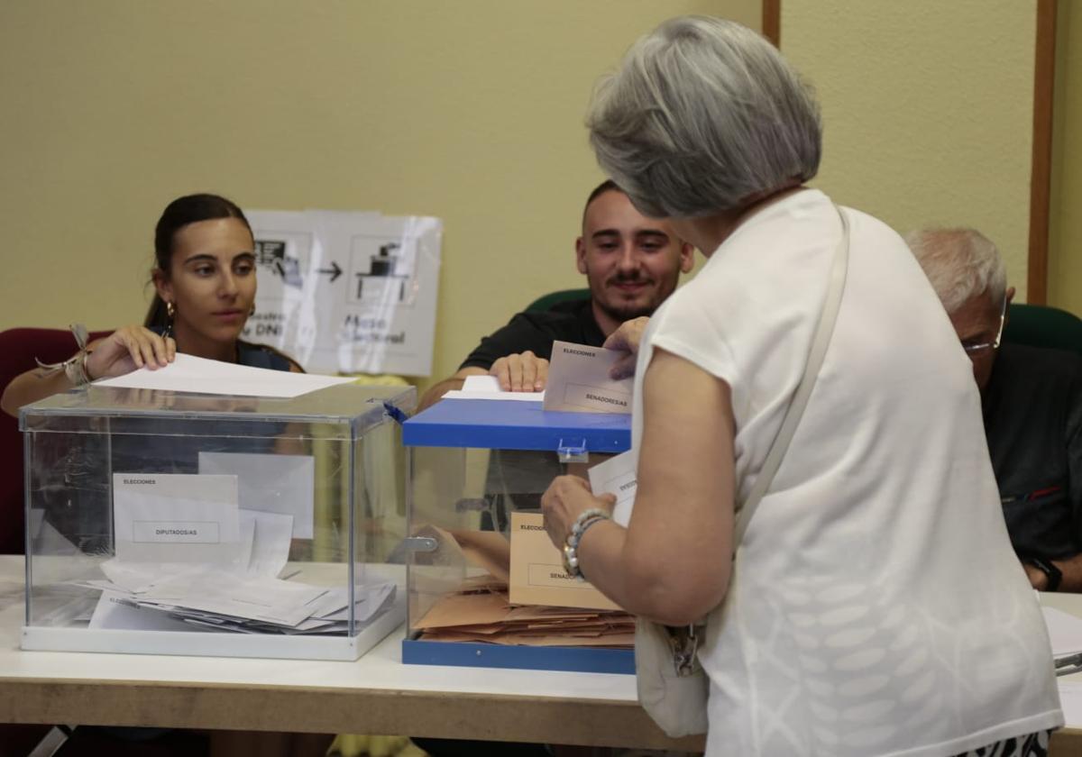 Una mujer desposita su voto en las urnas de Salamanca.