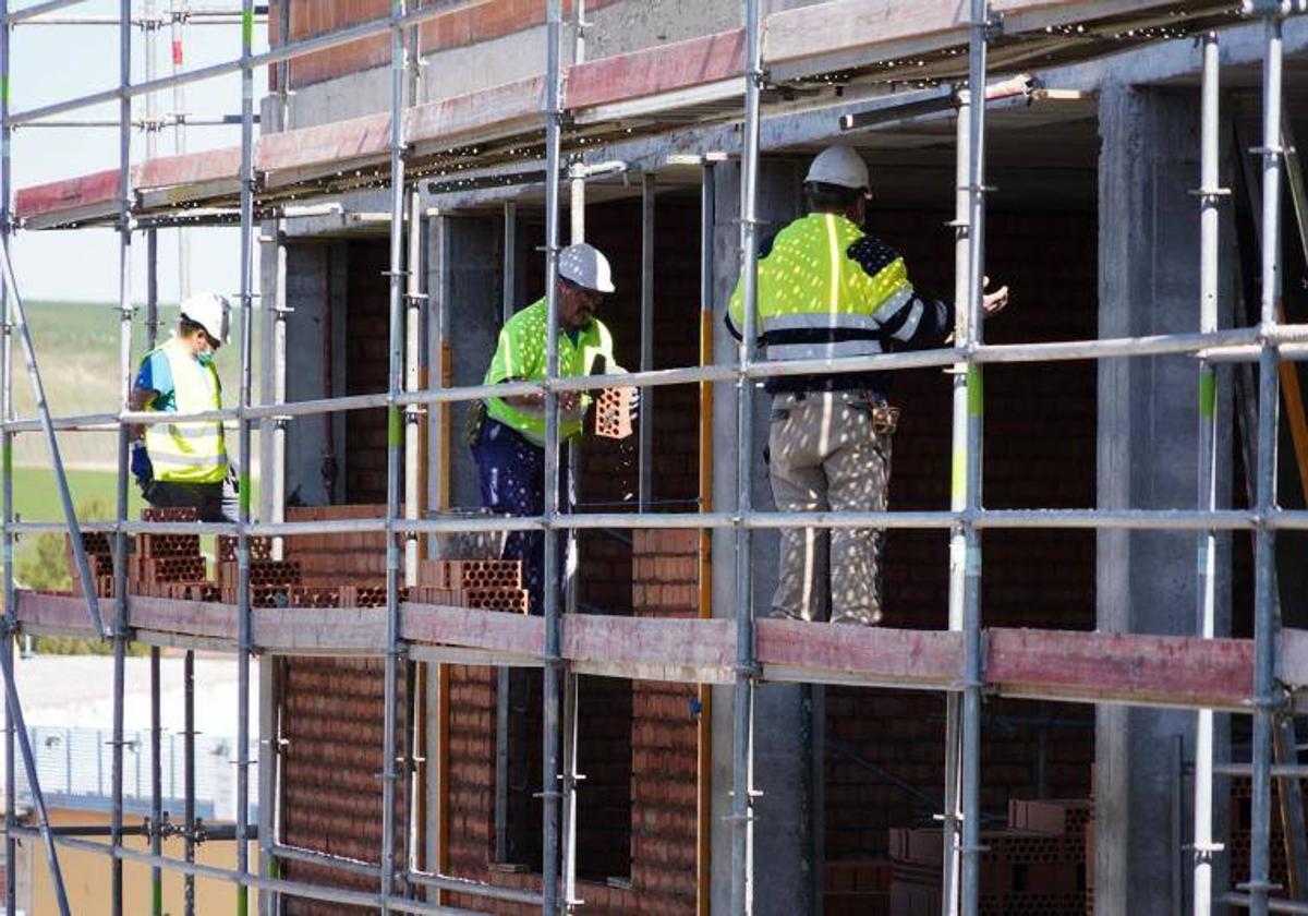 Obreros subidos en un andamio en la construcción de un edificio en Salamanca.