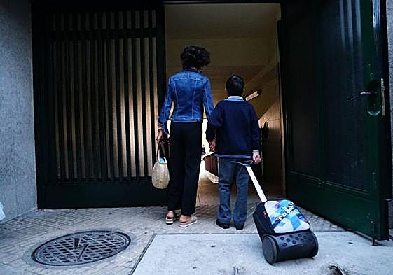 Un niño entrando a la escuela de la mano de su madre en un colegio de Salamanca.