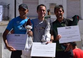 Los tres primeros clasificados posan en el podio con sus trofeos.