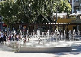 Varios niños se refrescan en la fuente de La Alamedilla.