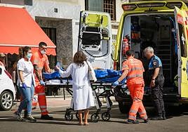 Los servicios de emergencias introducen a la mujer herida en la ambulancia.