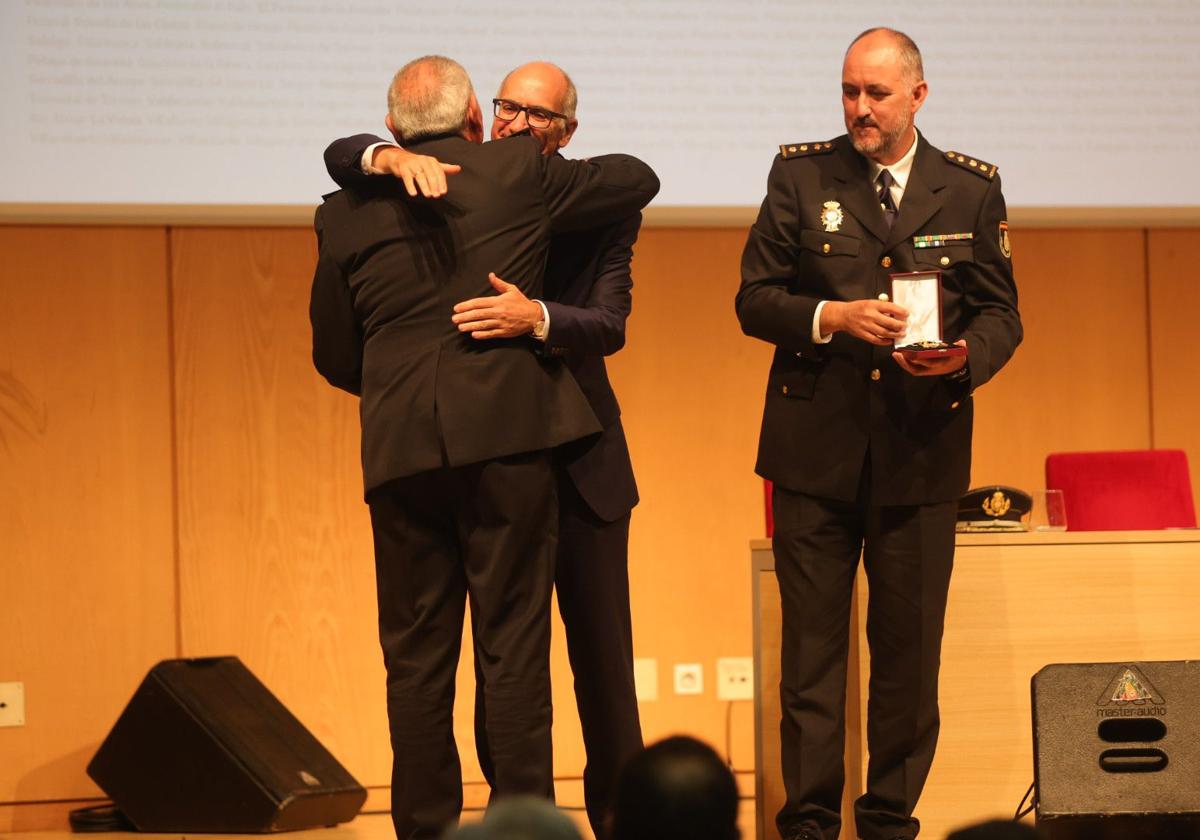 Javier Iglesias abraza a uno de los cargos de la Policía Nacional tras entregarles la medalla.