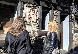 Dos personas se disponen a entrar en un alojamiento de turismo rural.