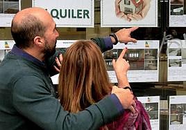 Una pareja observa ofertas de pisos.