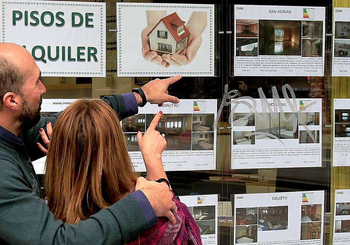 Una pareja observa ofertas de pisos.