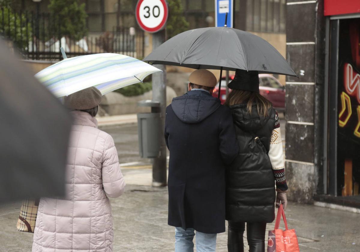 Varias personas pasean con paraguas por Salamanca.