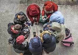 Un grupo de jóvenes en torno a sus móviles y dispositivos.