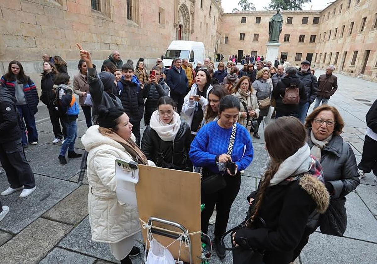 Grupos de turistas buscan la rana en la fachada de la Universidad.
