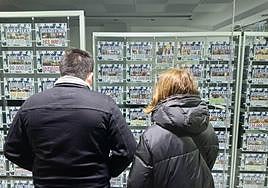 Una pareja observa los anuncios de una inmobiliaria en Salamanca.