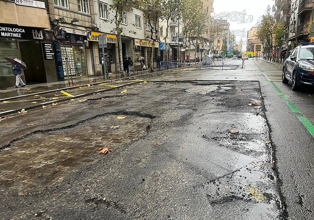 Imagen principal - Trozos del antiguo empedrado bajo el asfalto roto en Torres Villarroel.