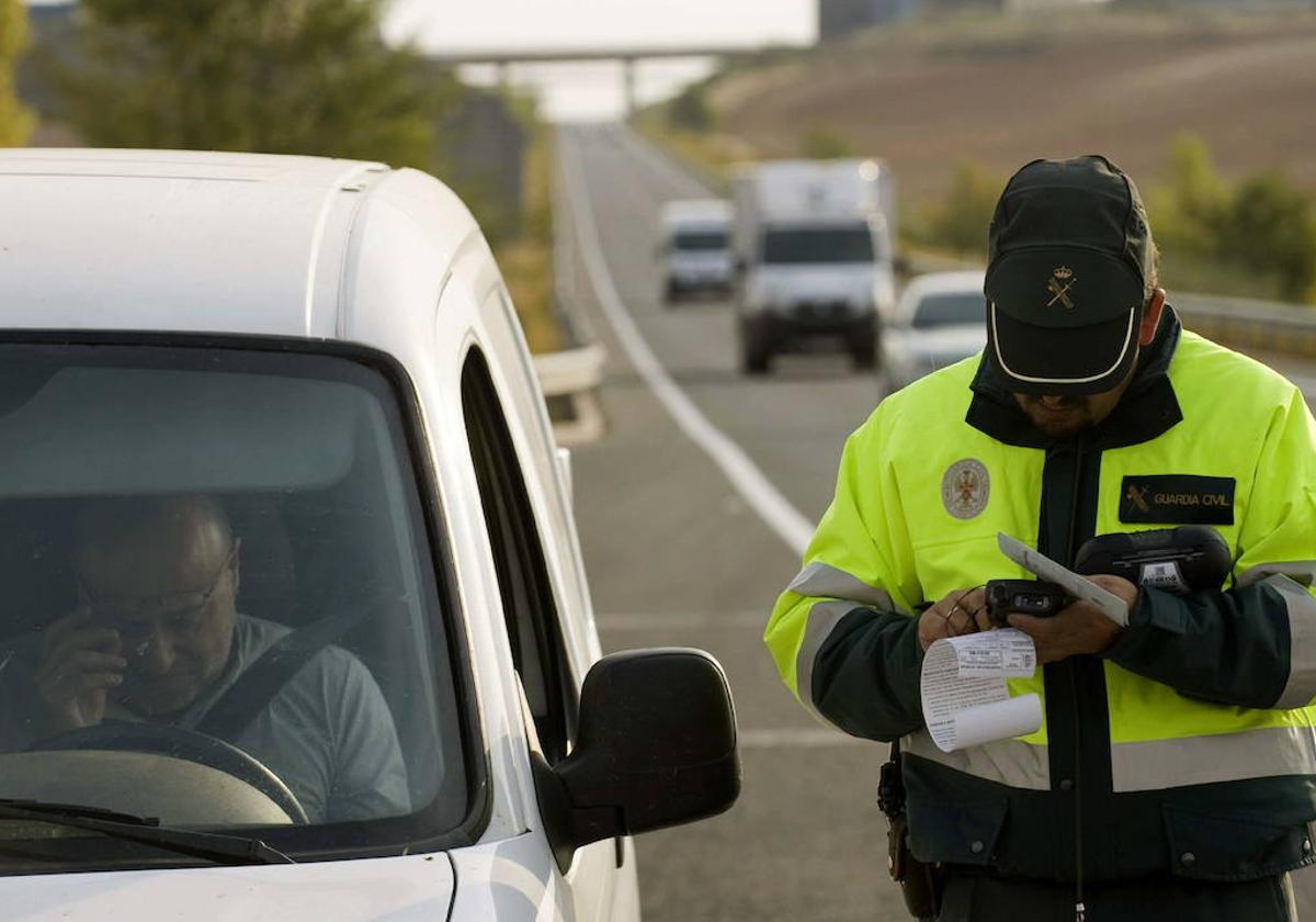 Un Guardia Civil multa a un conductor en una imagen de archivo.