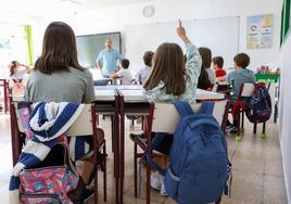 Una alumna levanta la mano para hacer una pregunta al profesor en un aula de Castilla y León.