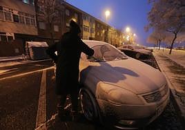 Conductor quitando hielo de un coche en Salamanca este diciembre.