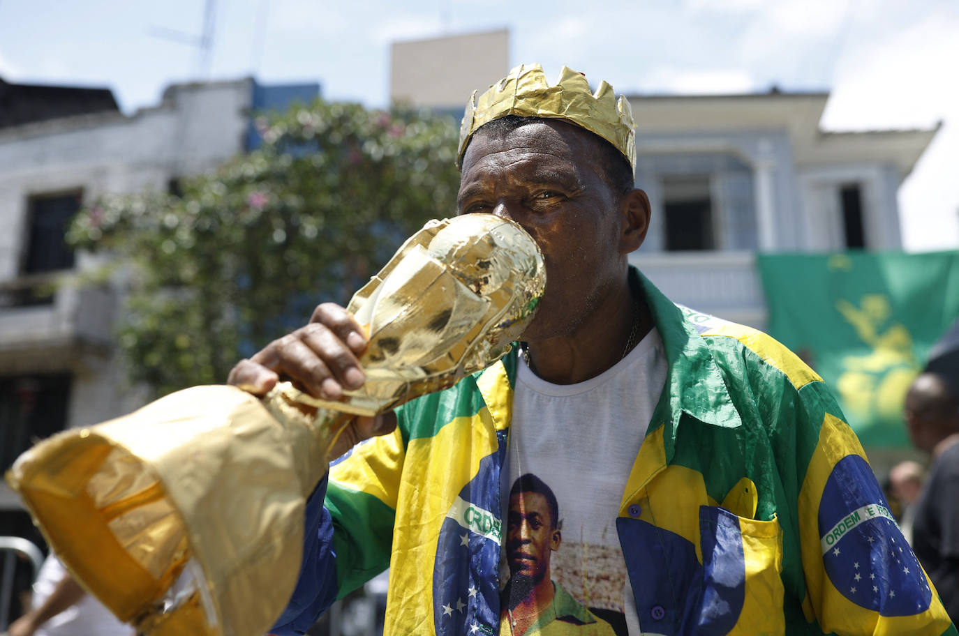 Un aficionado besa una réplica del trofeo de la Copa del Mundo mientras hace cola para presentar sus respetos a Pelé. 