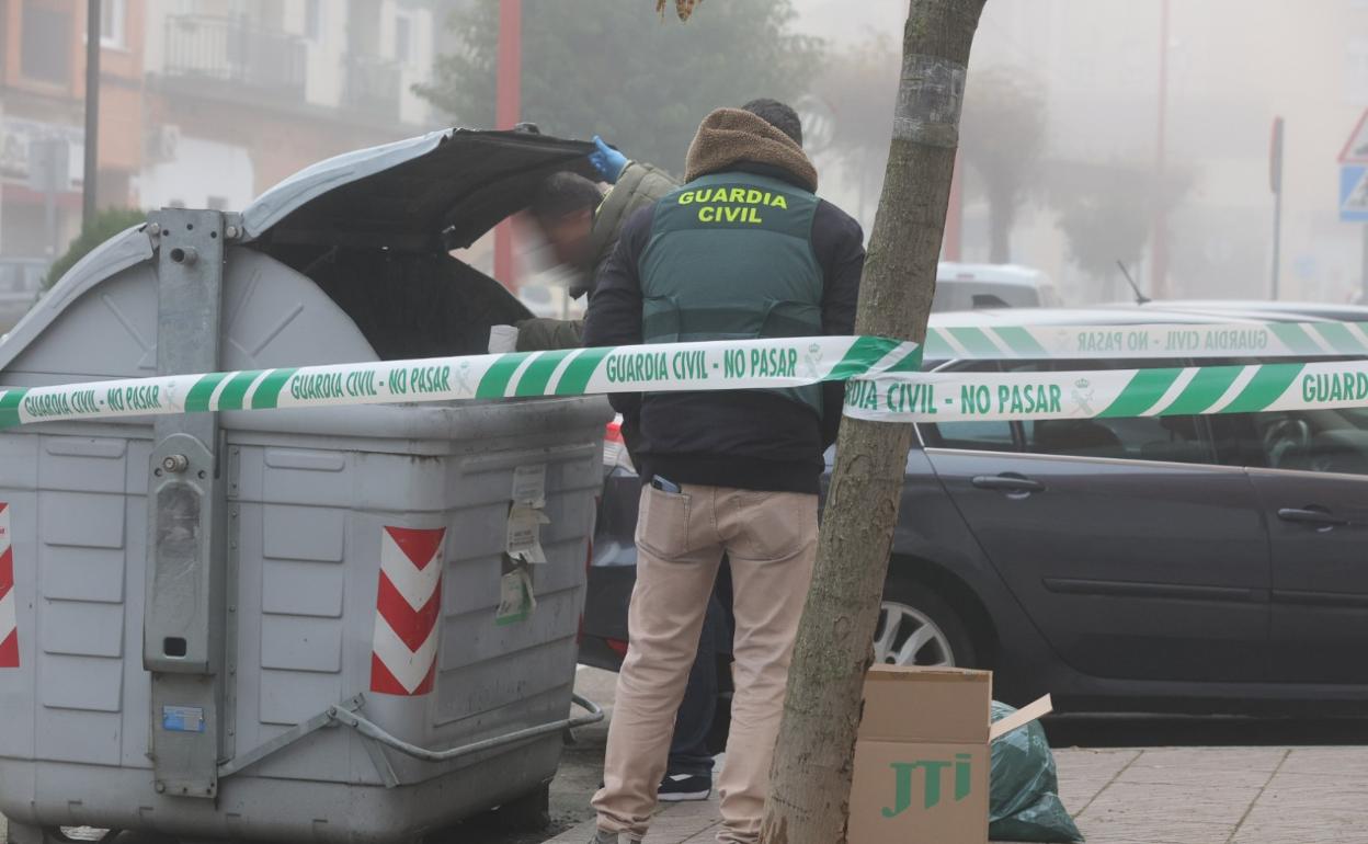 Dos agentes de la Benemérita investigan en un contenedor de la zona.