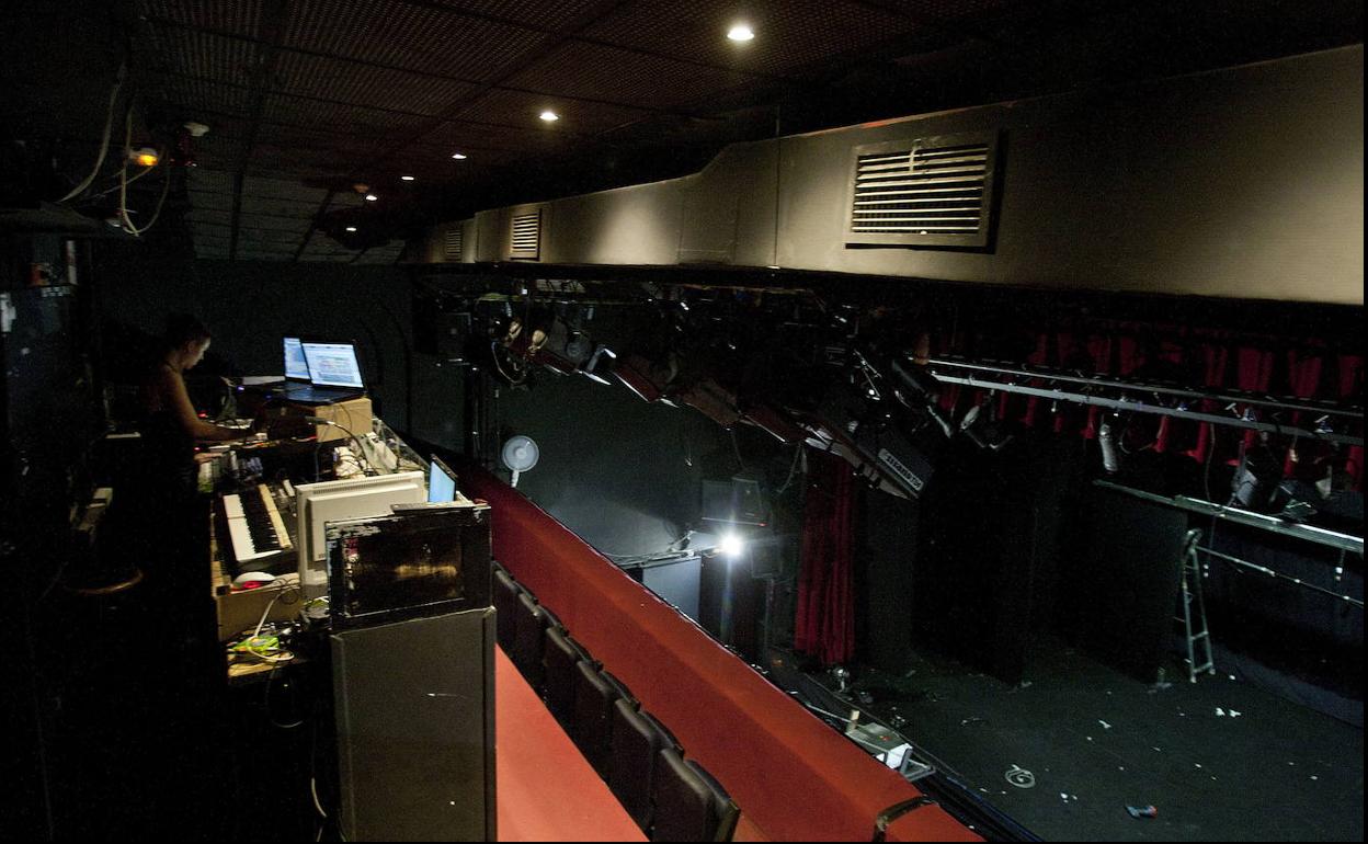 Una técnica de sonido, luz y maquinaria trabaja en un teatro.