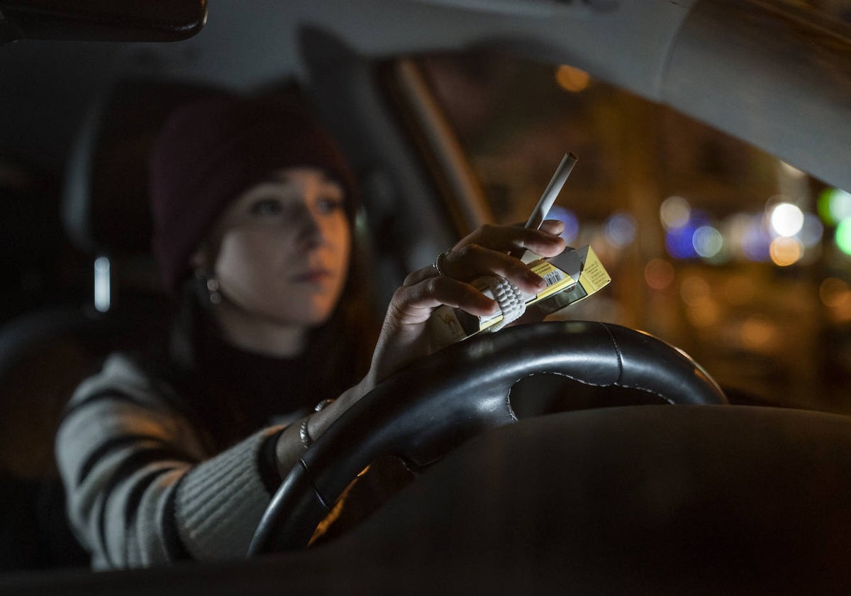 Una conductora con un cigarro en la mano