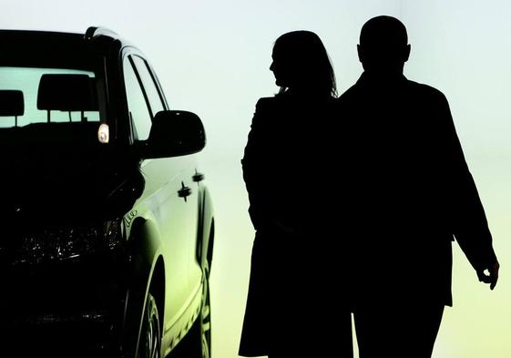 Una pareja observa un coche en un concesionario.