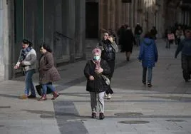 Mujer con mascarilla paseando por la calle Toro