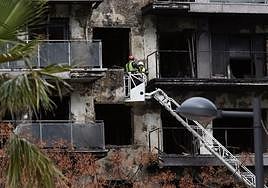 Los bomberos extraen pertenencias de las personas afectadas por el incendio de Valencia.