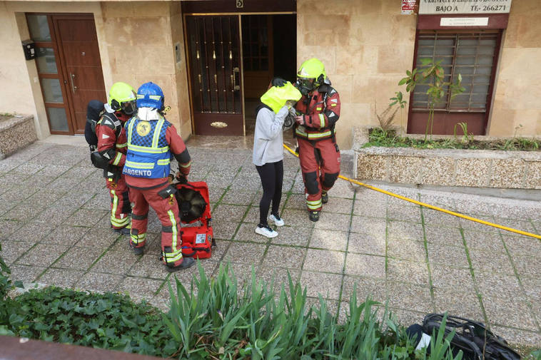 Bomberos desalojando el edificio en el que se ha originado el incendio