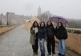 Varias jóvenes, en el Puente Romano y al fondo las catedrales.