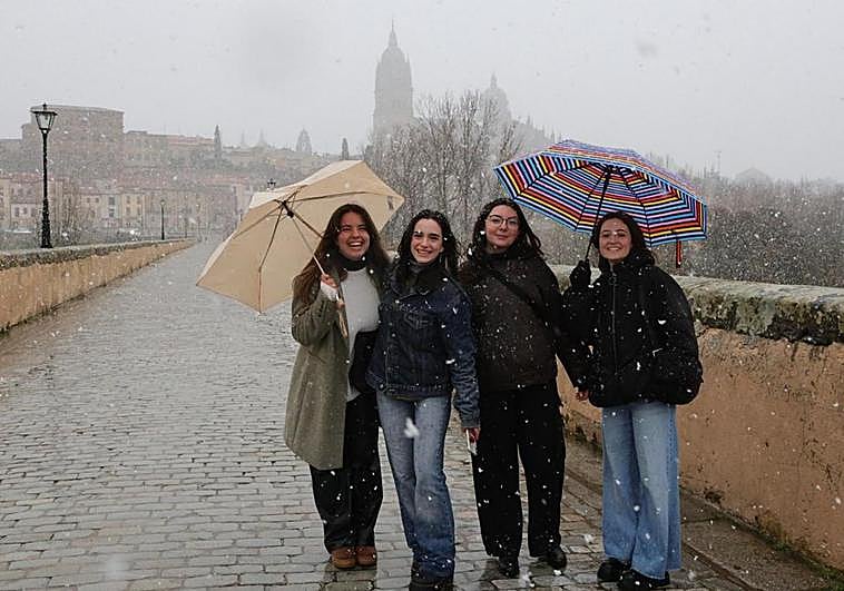 Varias jóvenes, en el Puente Romano y al fondo las catedrales.