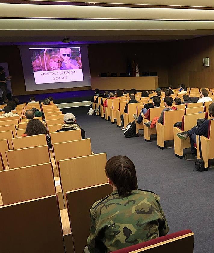 Imagen secundaria 2 - Galán, enseñando una huella en su móvil, con la colaboradora de Salamancahoy, Ana Carlos, y el auditorio durante su charla.