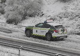 La Guardia Civil de Tráfico en una carretera cortada por la nieve.