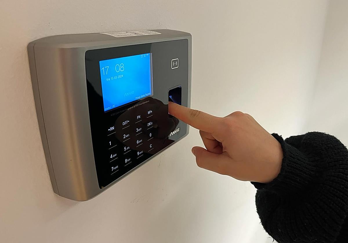 Una trabajadora firma con su huella a la entrada a su puesto de trabajo.