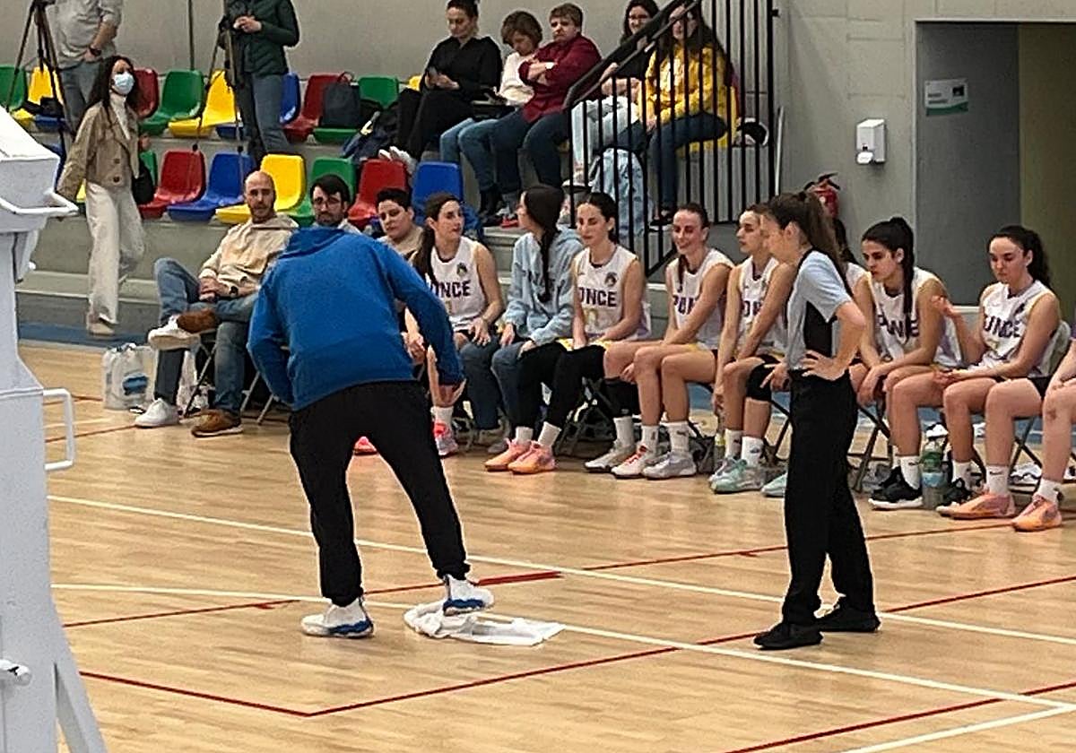 Un entrenador de la cantera de Avenida limpia el agua caída en el parqué durante un día de lluvia en un partido en el Anexo de Würzburg.
